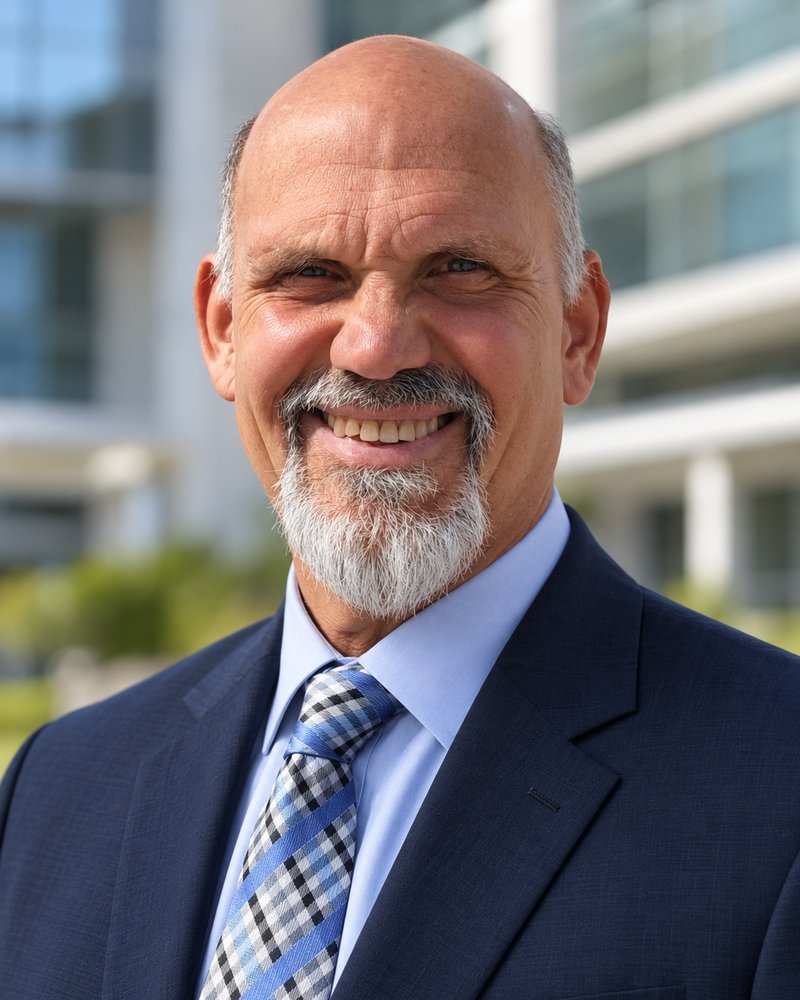Russ L'HommeDieu, DPT, smiling, in a navy suit